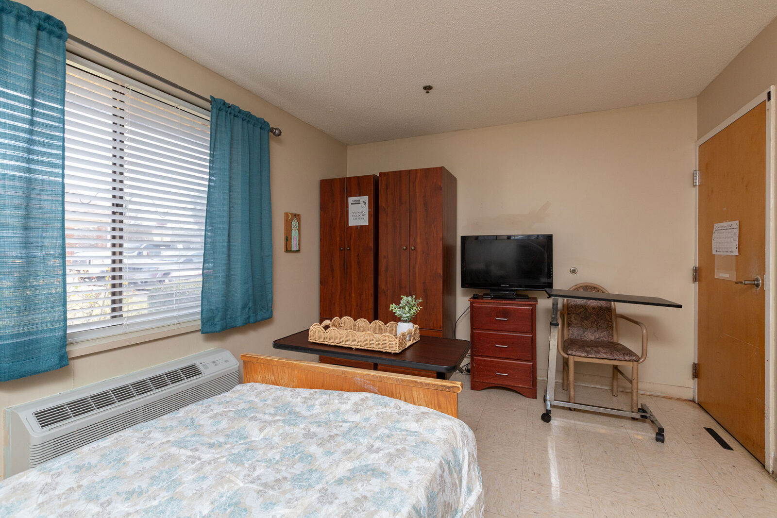 Cozy room with bed, TV, and workspace.